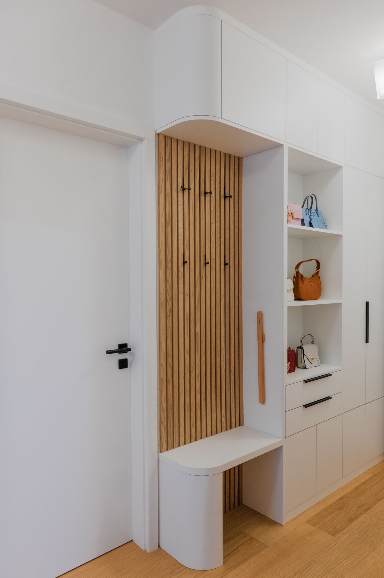 Entry niche with a bench, wooden slats and coat hooks
